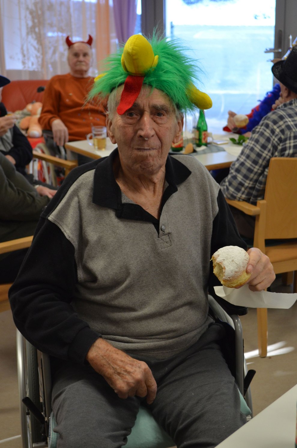 Ein Bewohner hält einen Krapfen in der Hand.