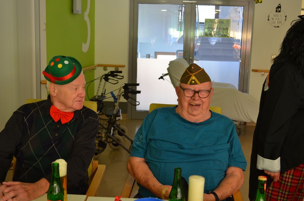 Zwei Bewohner haben ein Bier vor sich stehen.